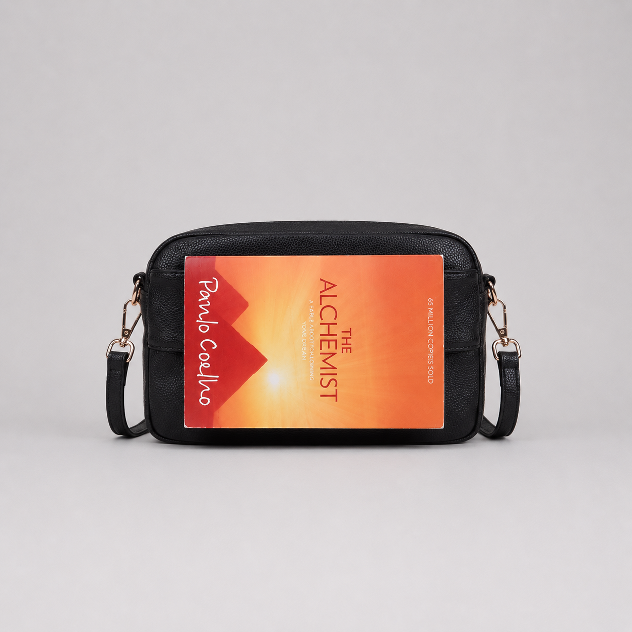 The Daily Black bookmark-inspired crossbody bag holding a book