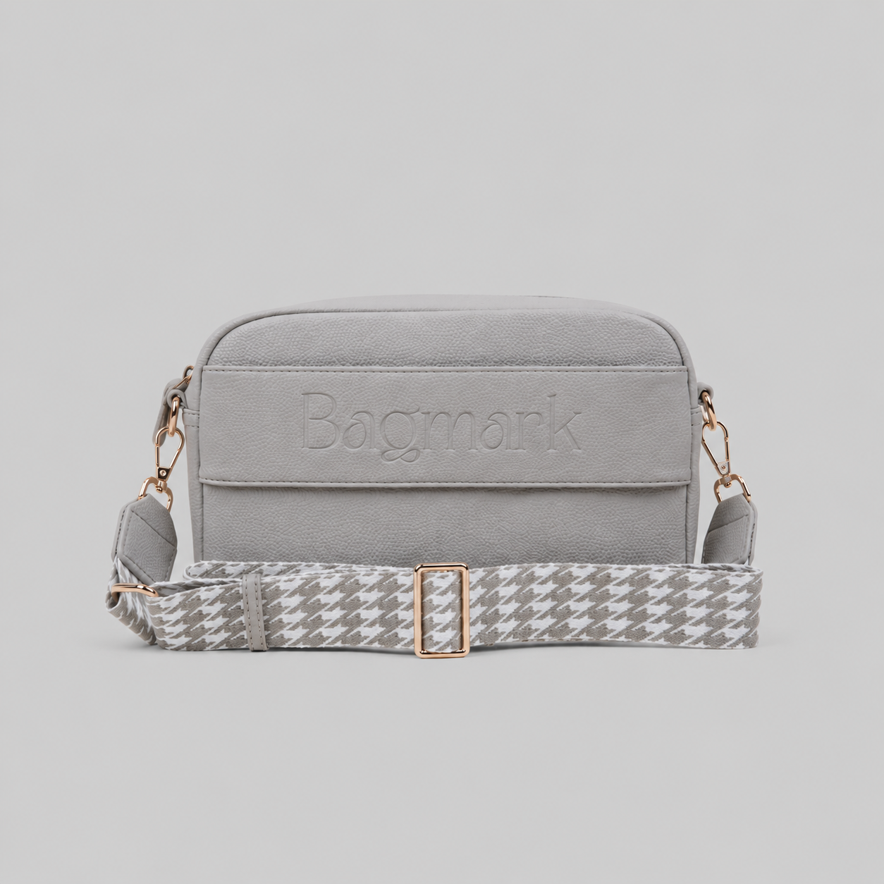 The Daily in Stone bookmark crossbody bag with a patterned webbing strap